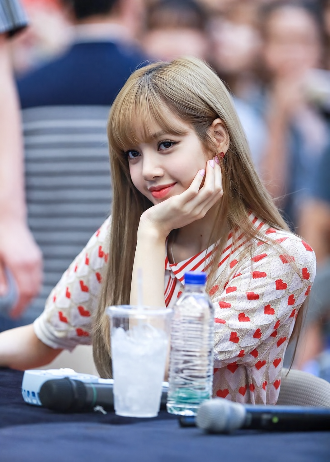 Ilustrasi suntingan AI berdasarkan foto Lisa di fansign BLACKPINK, AK Plaza, Bundang, 24 Juni 2018. Detail wajah, rambut, pakaian, dan mikrofon direkonstruksi; bukan cuplikan film atau dokumentasi acara 2026.